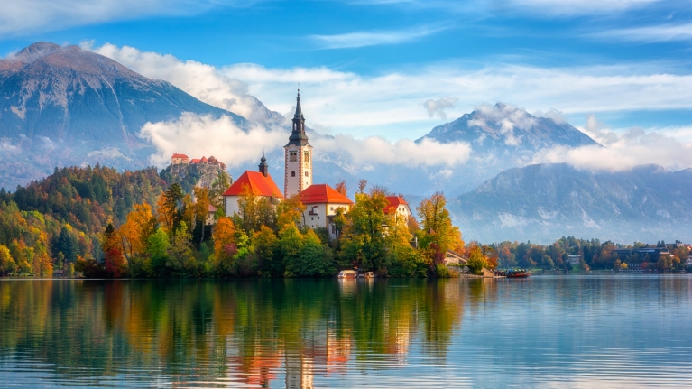 A view of Lake Bled and the island in the center of the lake, with autumn leaves 